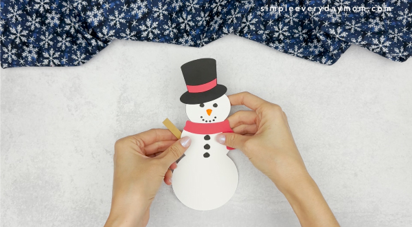 hand gluing the arm stick of how to catch a snowman craft