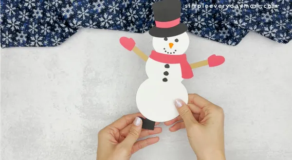 hand gluing the feet of the how to catch a snowman craft