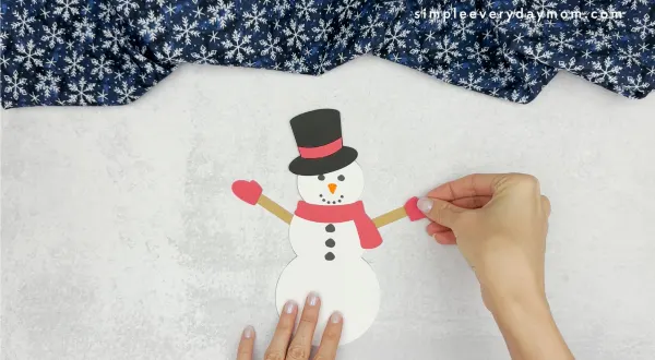 hand gluing the snowman hands