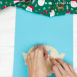 hand gluing the face of the torn paper elf craft