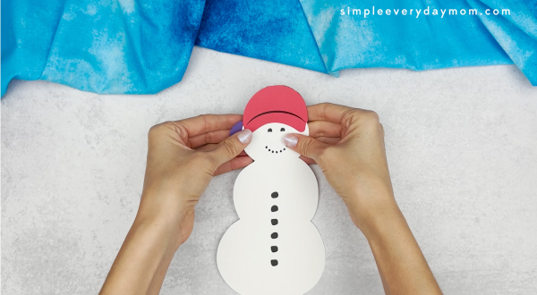 hand gluing the earmuffs of the snowmen at night craft