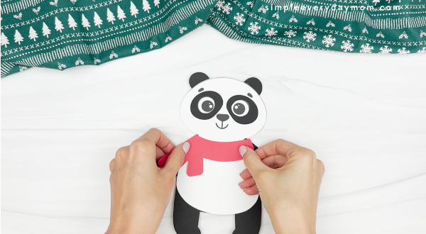 hand gluing the scarf of the panda christmas craft