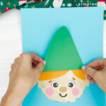 hand gluing the hat of torn paper elf c raft