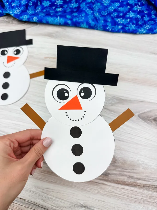 holding the snowman shape craft