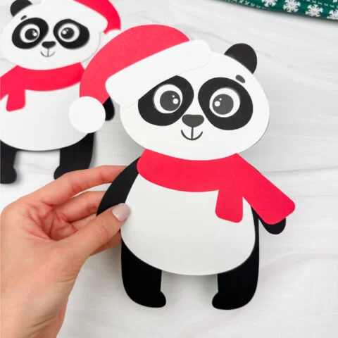 holding the panda Christmas craft with one craft on the background