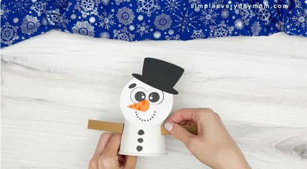 hand gluing the arms of snowman craft