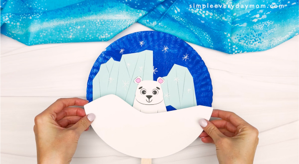 hand gluing the snow on the bottom part of paper plate