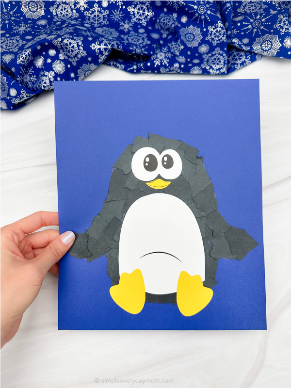holding the torn paper penguin craft