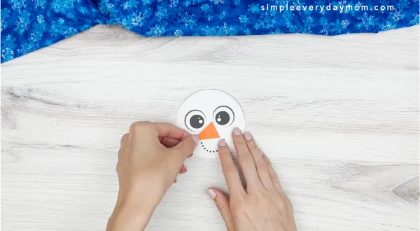 hand gluing the nose of snowman craft