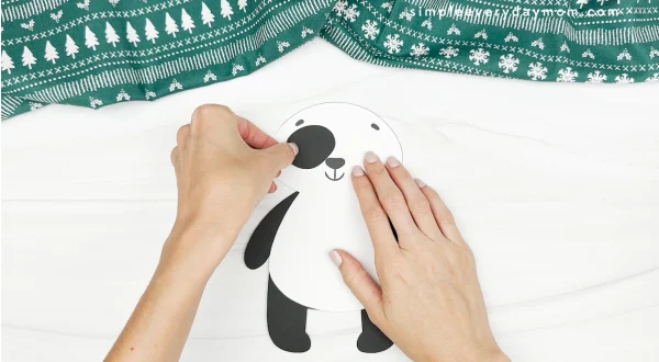 hand gluing eye spot to panda christmas craft