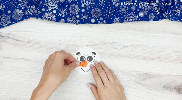 hand gluing the nose of snowman craft
