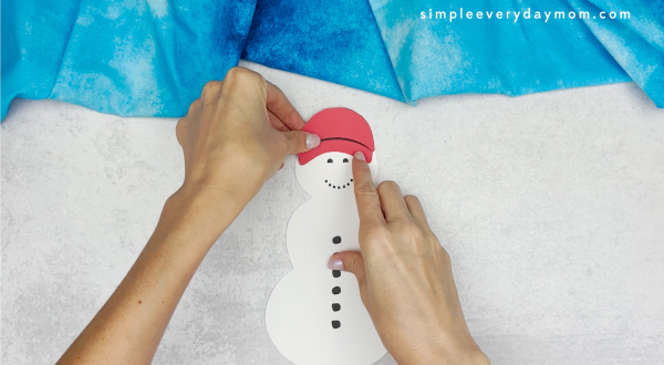 hand gluing the hat of the snowmen at night craft