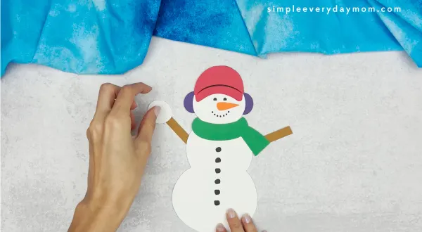 hand gluing the arms of the snowmen at night craft