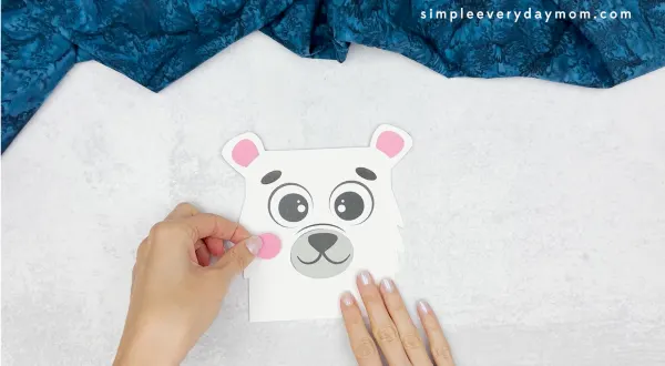 hand gluing the cheeks of the polar bear tissue box craft