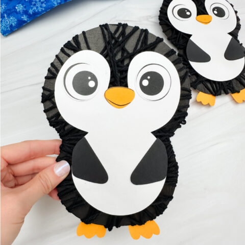holding the yarn penguin craft with background