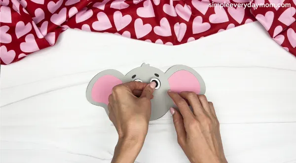 hand gluing the eyes of the elephant valentine craft