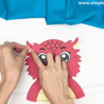hand gluing the small horns of the chinese dragon craft