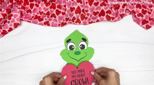 hand gluing the heart of the grinch valentine craft