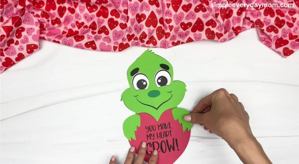 hand gluing the hands of the grinch valentine craft