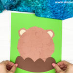 handgluing the rocks of the torn paper groundhog craft