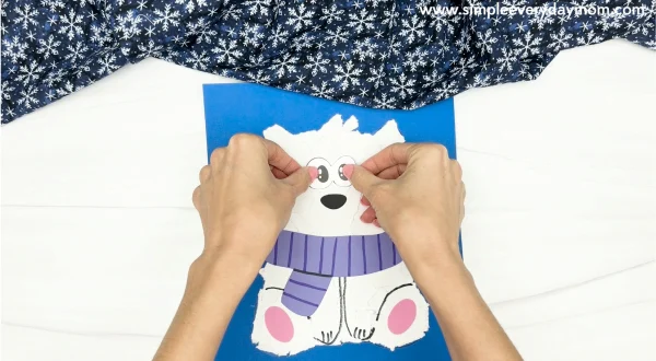 hand gluing the eyes of torn paper polar bear craft