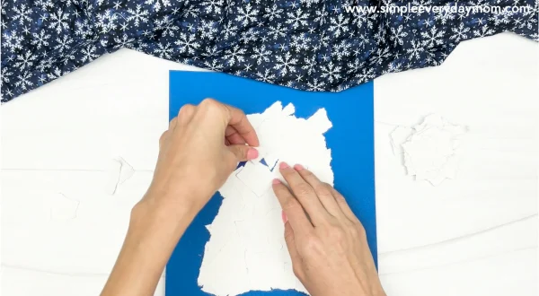 hand gluing the torn paper to the polar bear craft template
