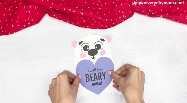 hand gluing the heart to the body of polar bear valentine craft