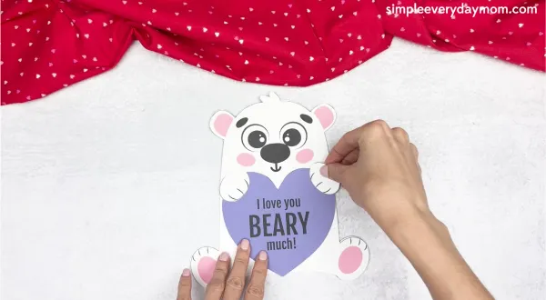 hand gluing the hand of polar bear valentine craft