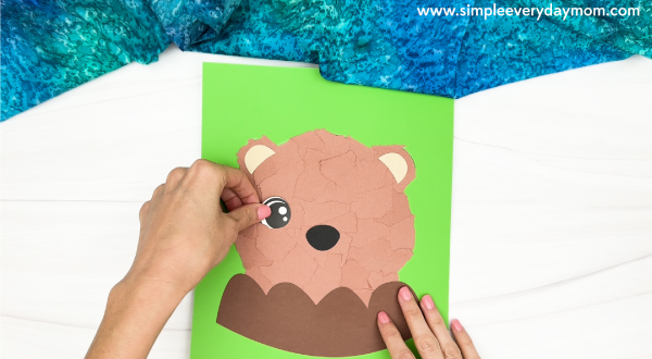 hand gluing the eyes of the torn paper groundhog craft