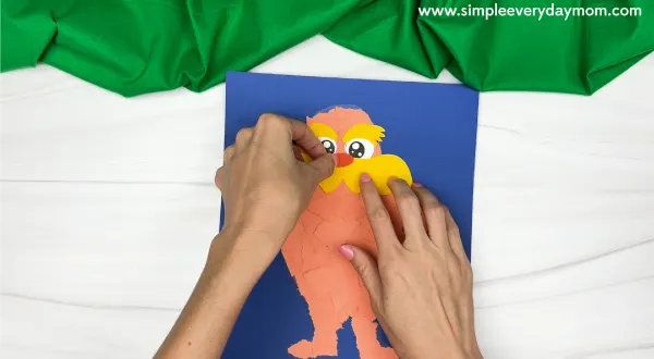 handgluing the mustache and nose of torn paper lorax craft