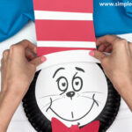 hand gluing the hat to the cats head