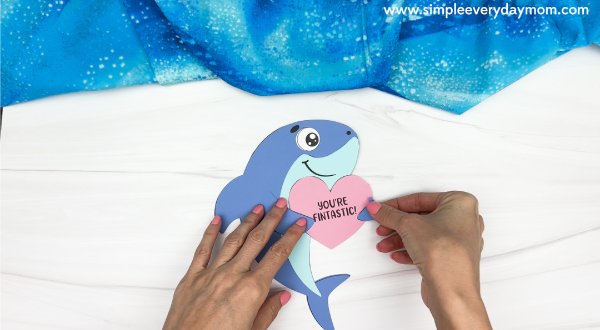 hand gluing the right fin to the heart of shark valentine craft