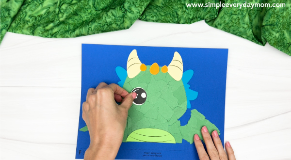 hand gluing the eyes of the torn paper dragon craft