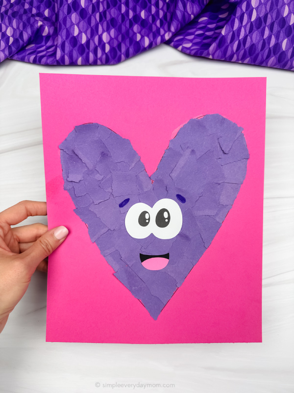 holding torn paper heart craft