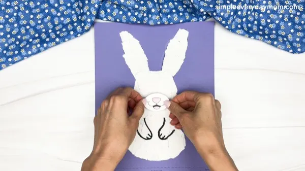 hand gluing the mouth of the torn paper bunny craft
