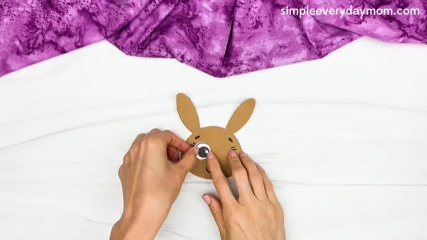 hand gluing eye of Bunny Paper Cup Craft