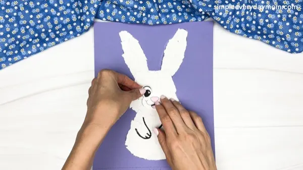 hand gluing the eye of the torn paper bunny craft