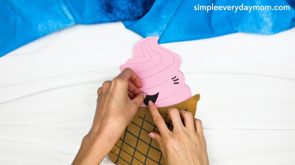 hand gluing the mouth of paper plate ice cream craft template