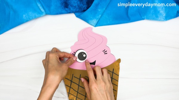 hand gluing the eyes of paper plate ice cream craft template