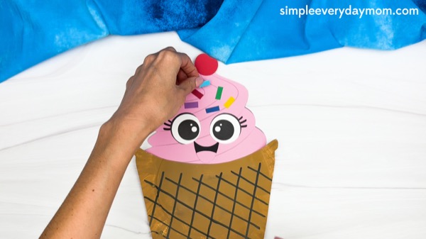 hand gluing the sprinkles of paper plate ice cream craft template