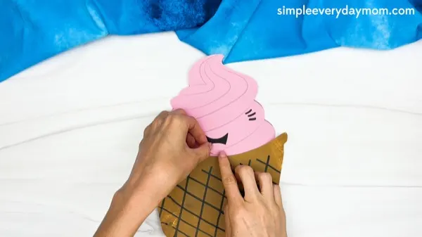 hand gluing the tongue of paper plate ice cream craft template