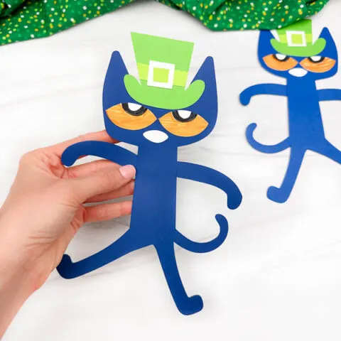 hand holding the pete the cat craft with background on side