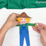 Hand gluing the straw gloves of the Scarecrow Photo Craft