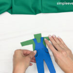 Hand gluing the overall pants of the Scarecrow Photo Craft