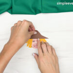 Hand gluing the hat of the Scarecrow Photo Craft