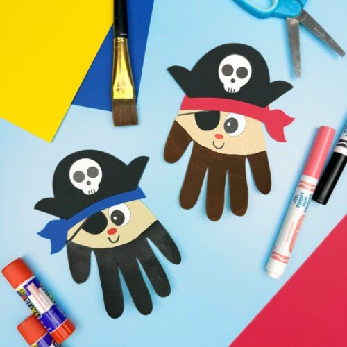 Two pirate handprint crafts displayed with craft supplies like glue sticks, markers, scissors, and paper—fun pirate-themed art project for preschool and kindergarten kids.