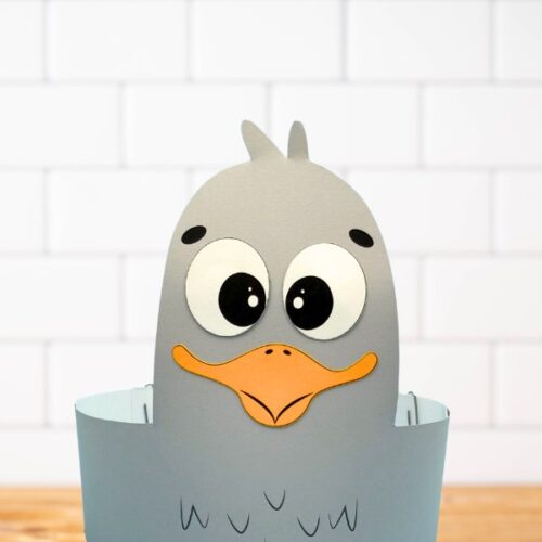Adorable gray seagull headband craft made from paper and displayed on a wooden surface—fun and simple printable activity for kids with an ocean animal theme.