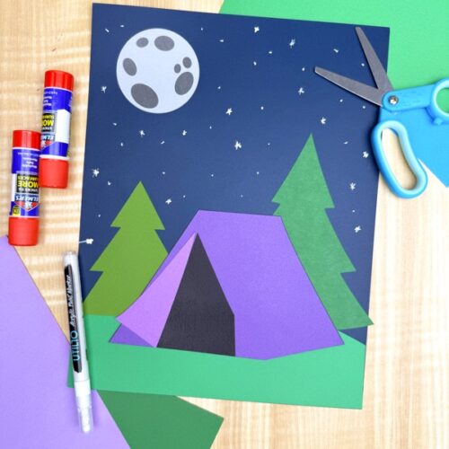 Purple camping tent craft for kids displayed with glue sticks, scissors, and paper supplies. Easy preschool and kindergarten paper craft using a free printable night scene template.