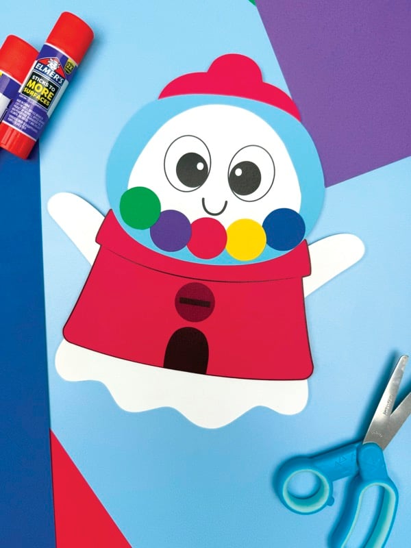 A completed craft of a gumball machine ghost next to craft supplies.