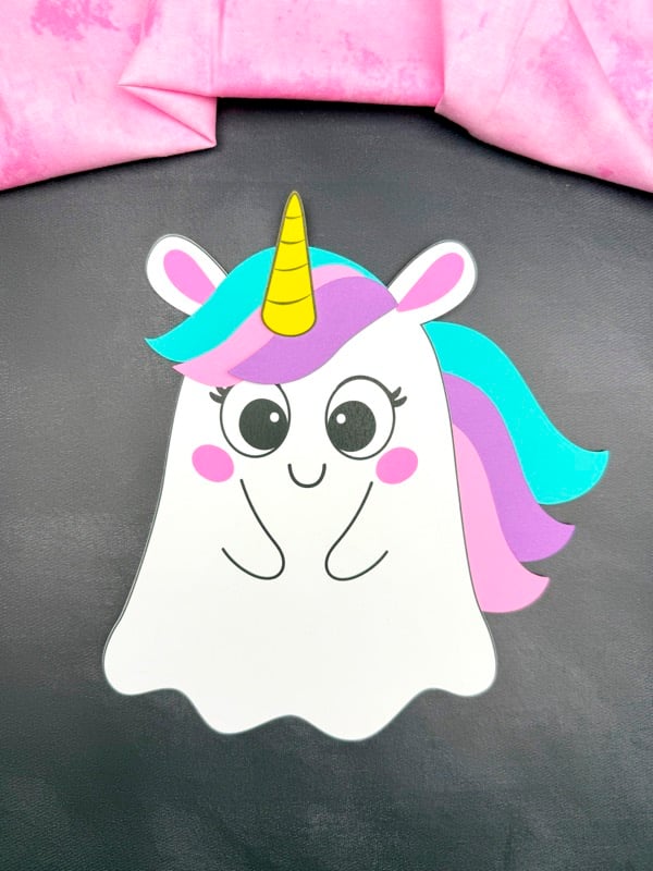 Unicorn ghost craft with a turquoise, purple, and pink mane, pink cheeks, and a yellow horn.
